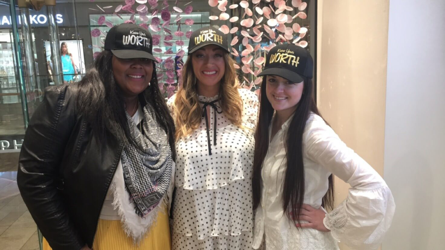 3 girls wearing know your worth caps at the Kendra Scott Home event
